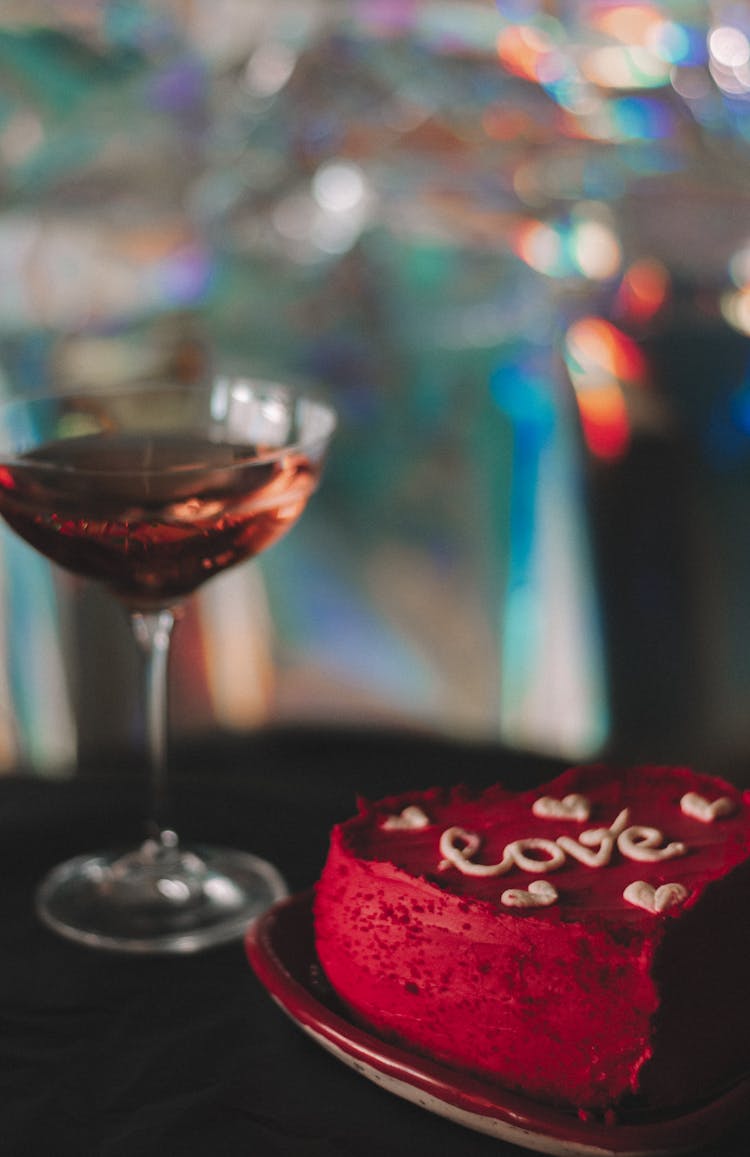 
A Close-Up Shot Of A Heart Shaped Cake Beside A Glass Of Wine