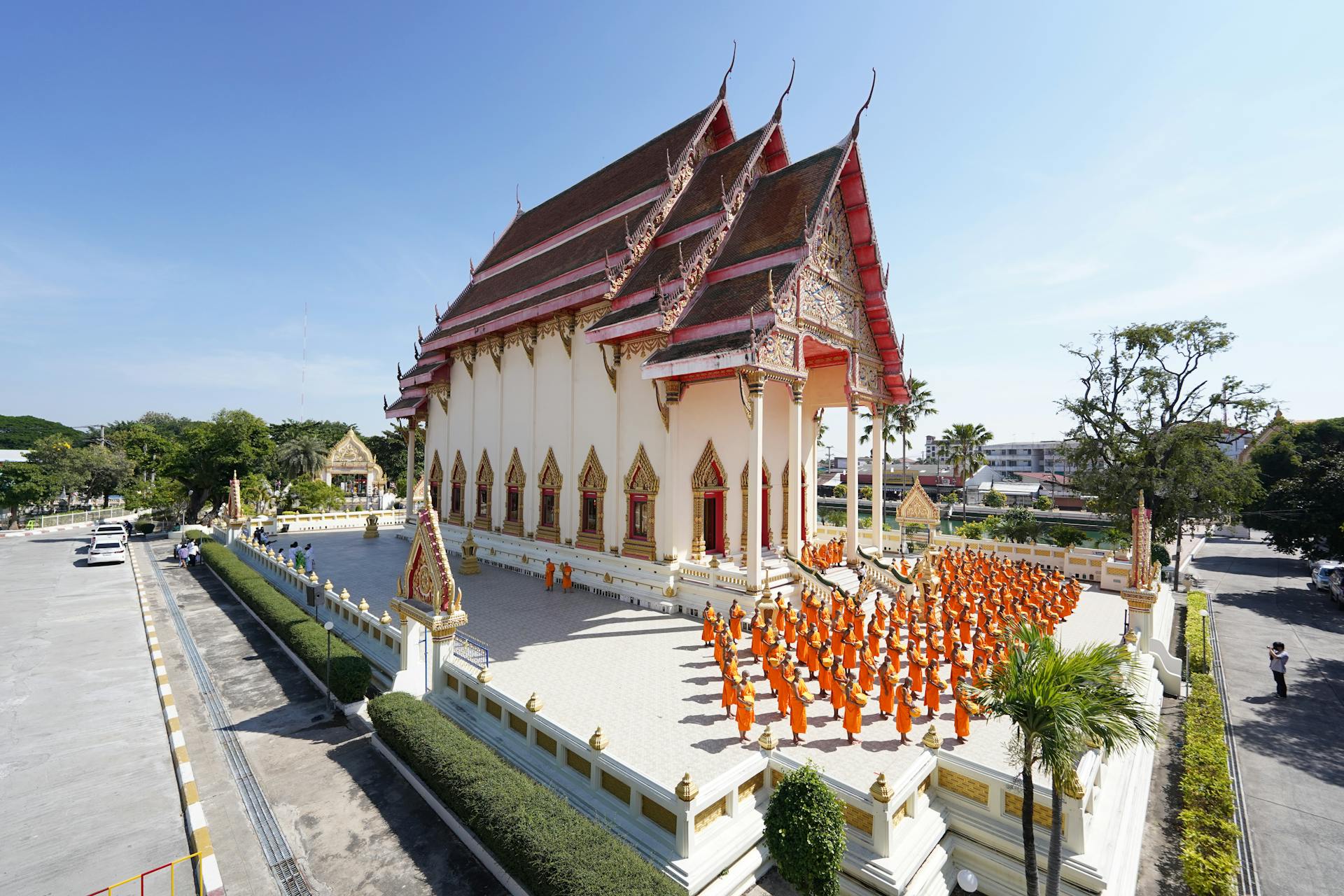 Monks in orange robes gather at Wat Klang Phra Aram Luang, Buriram, Thailand for a ceremony.