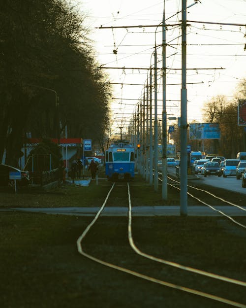 A Tram Near the Road with Vehicles