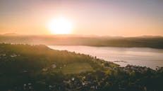 从鸟瞰视角捕捉到的日出景象令人惊叹，宁静的湖泊与周围的山丘尽收眼底