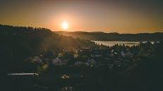 日落时分，从空中俯瞰湖边那个迷人的村庄，宁静而温暖的氛围油然而生