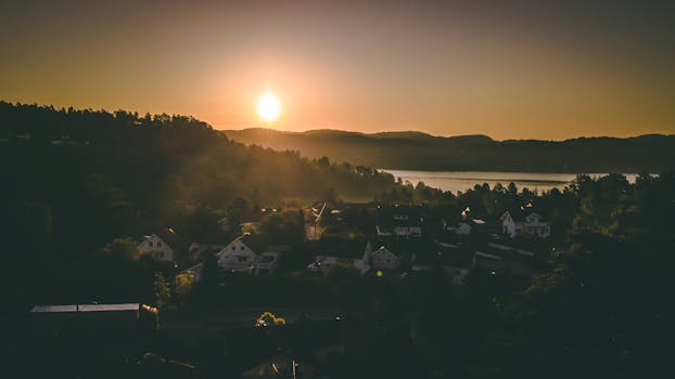 日落时分，从空中俯瞰湖边那个迷人的村庄，宁静而温暖的氛围油然而生
