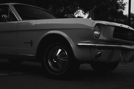 Black and white close-up of a classic vintage car parked outdoors.