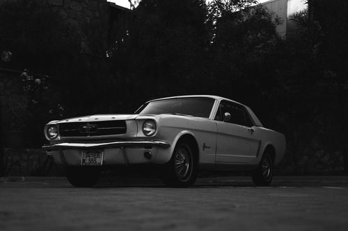 Free A vintage Ford Mustang car parked in a dark, atmospheric outdoor setting. Stock Photo