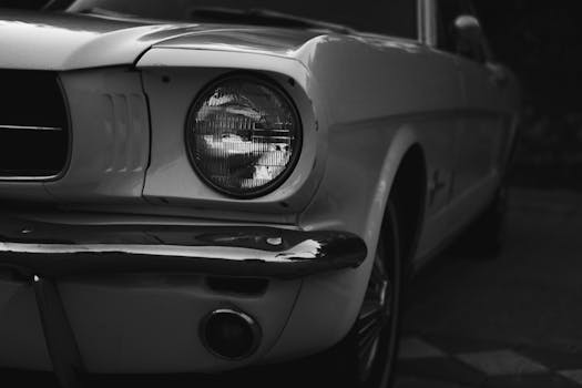 Grayscale close-up of a vintage car headlight showcasing classic design and retro styling.