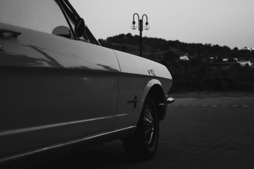 Free Black and white photo of a vintage car parked outdoors, capturing retro elegance. Stock Photo