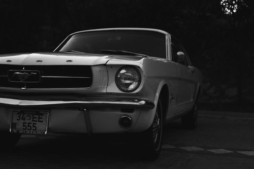 Free Close-up of a vintage Ford Mustang in grayscale, showcasing classic automotive design. Stock Photo