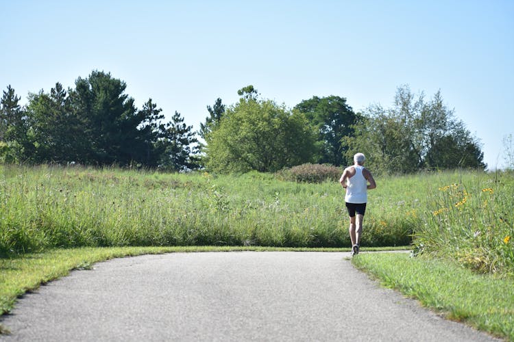 Elderly Man In White Tank Top Jogging