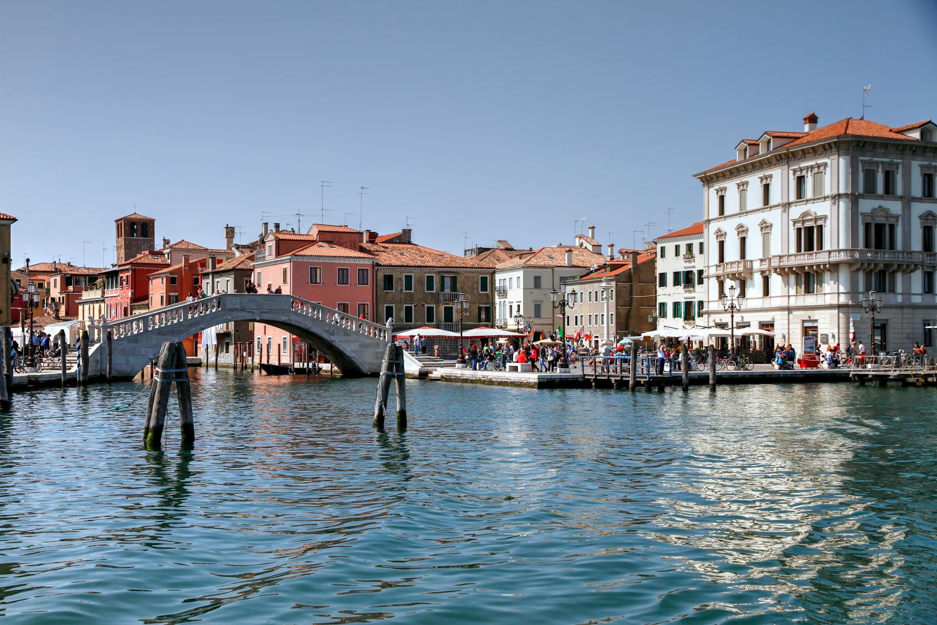 Picturesque canal scene with a historic bridge and colorful buildings in Venice.