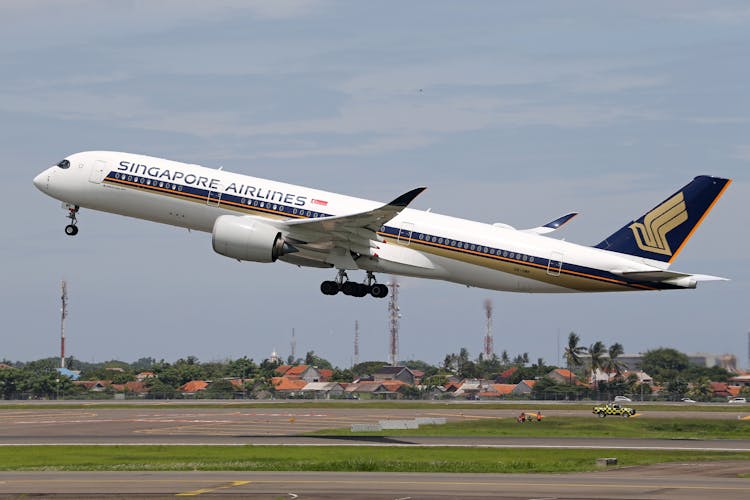 Airplane Taking Off And Houses In Background