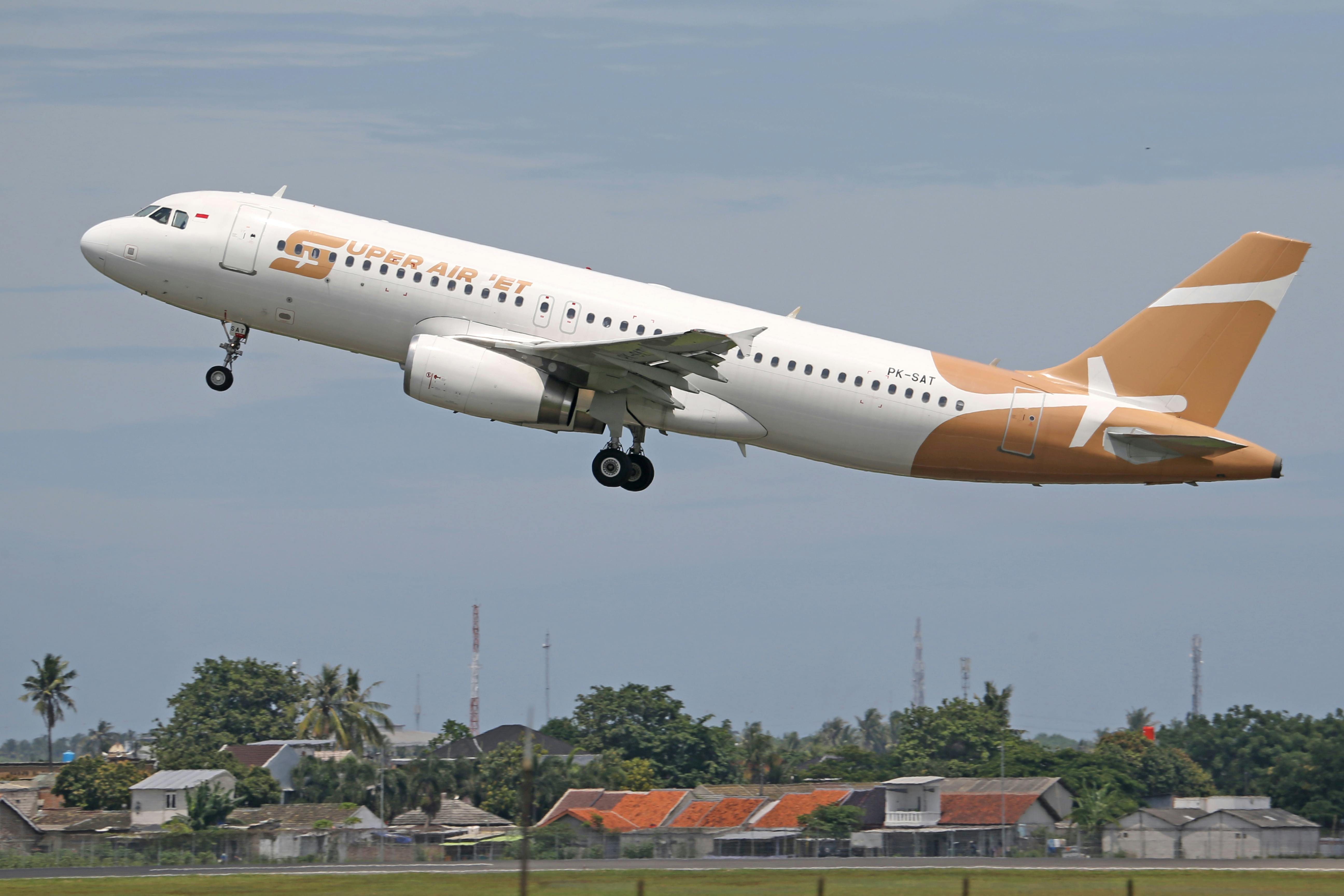 Commercial airliner Super Air Jet taking off against a clear sky, showcasing aviation and travel themes.