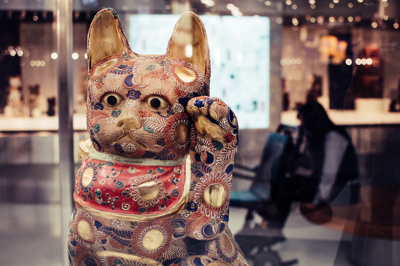 vibrant maneki neko figurine in a contemporary exhibit setting symboli