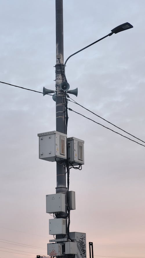 A Gray Electric Post Under Cloudy Sky