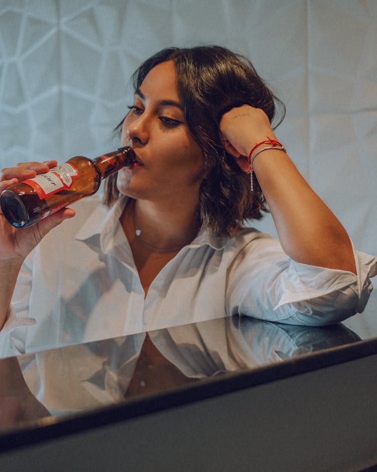 A Woman Drinking A Bottle Of Beer 