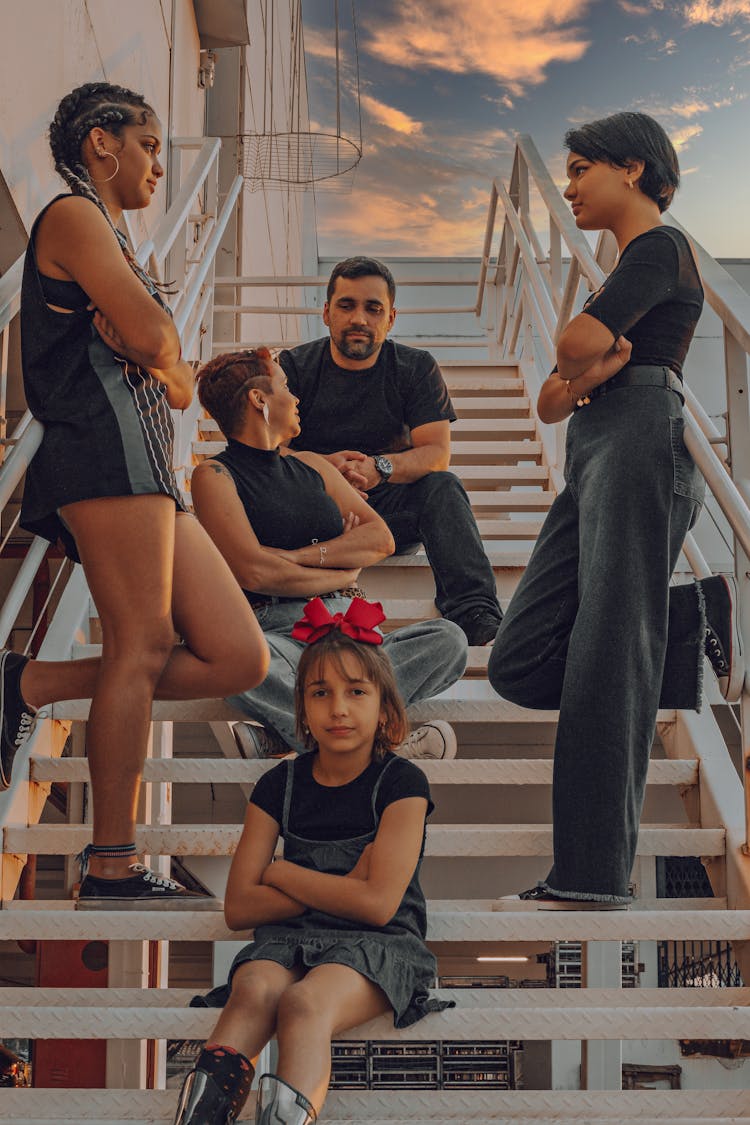 Family Posing On White Metal Stairs On A Beach