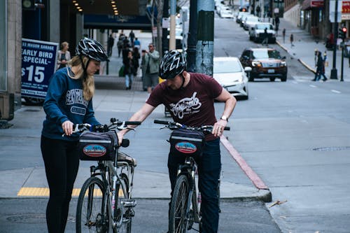 Man In Maroon Crew-neck T-shirt Beside Woman In Blue Sweatshirt At The Street