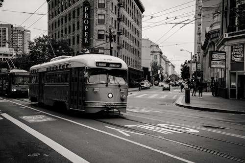 Free Grayscale Photography of Tram Near Buildings Stock Photo