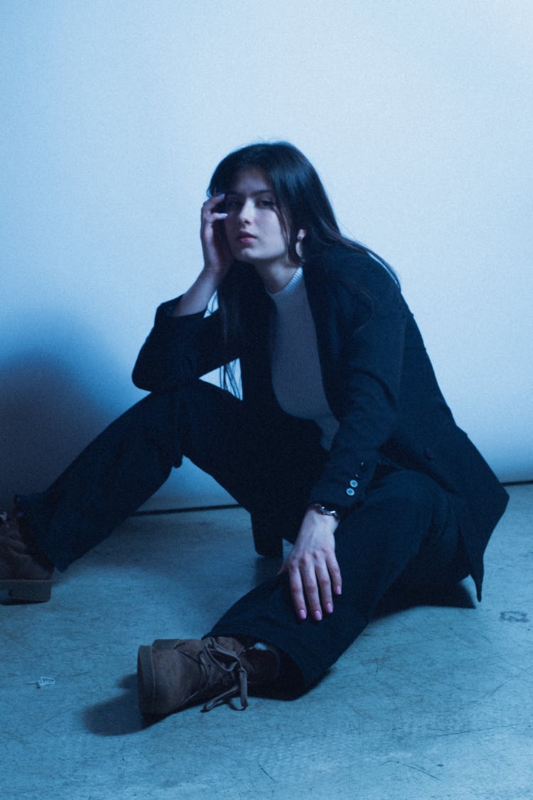 Woman In A Suit Sitting On The Floor 