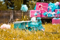 花园里，充满活力的玩具火车周围环绕着草地和色彩缤纷的包装礼物