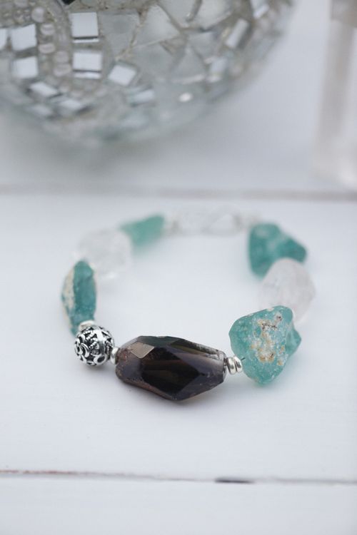 Free Close-up of a gemstone bracelet with unique beads and a mosaic background. Stock Photo