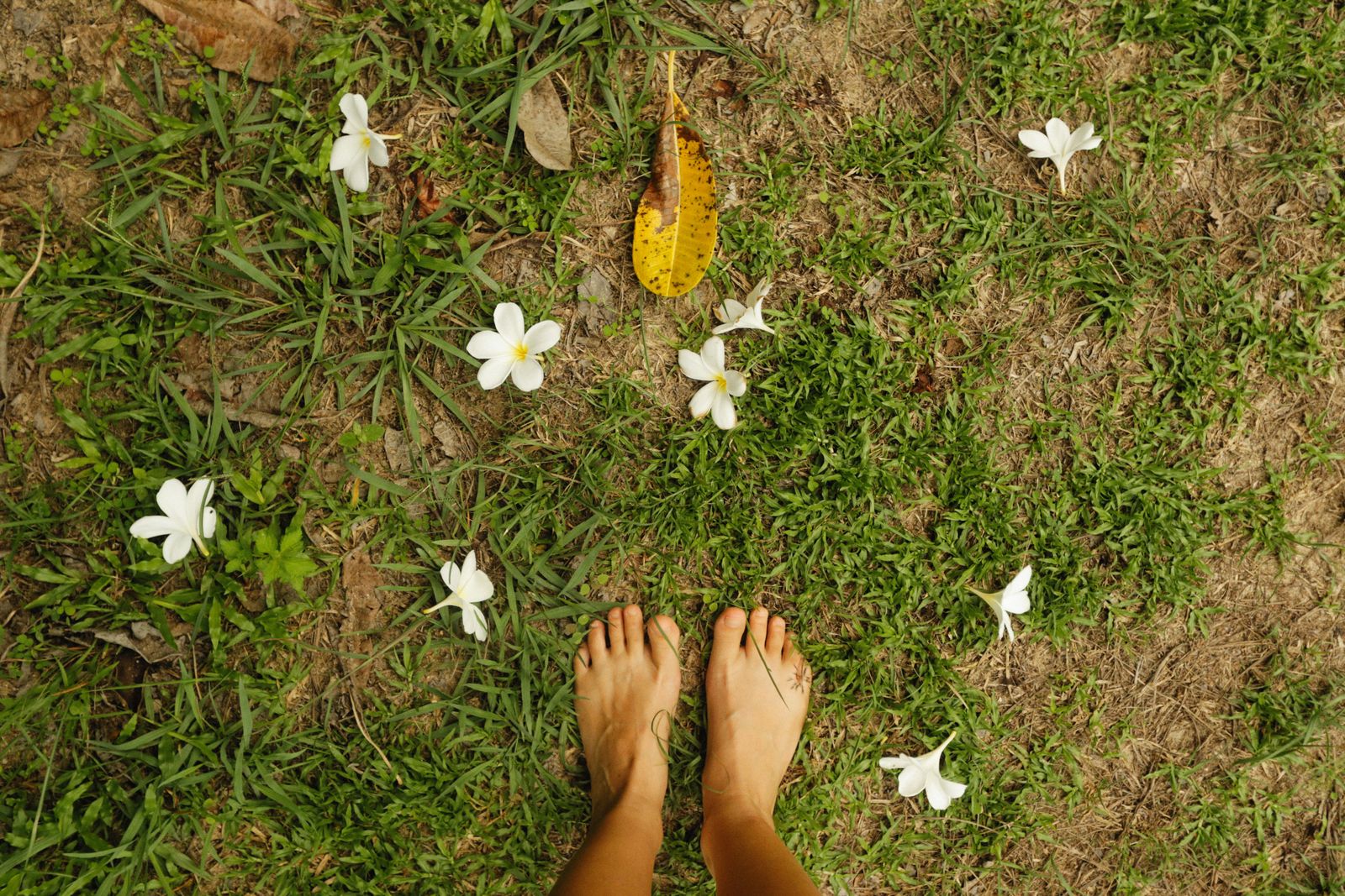 Close view of athletic shoes and feet on pavement, relevant to walking support for arch pain and foot drop