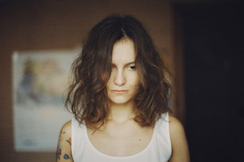 Woman in White Tank Top Looking Away