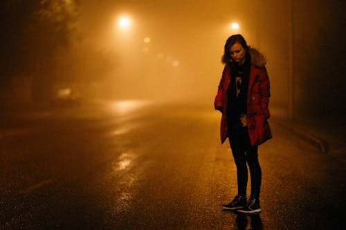 Free Woman Wearing a Jacket Standing on the Road Stock Photo