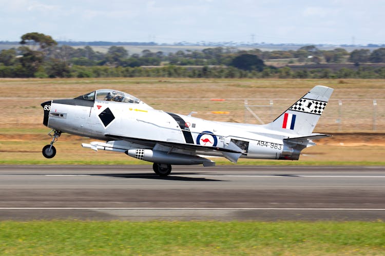 White And Red Jet Plane On Gray Asphalt Road