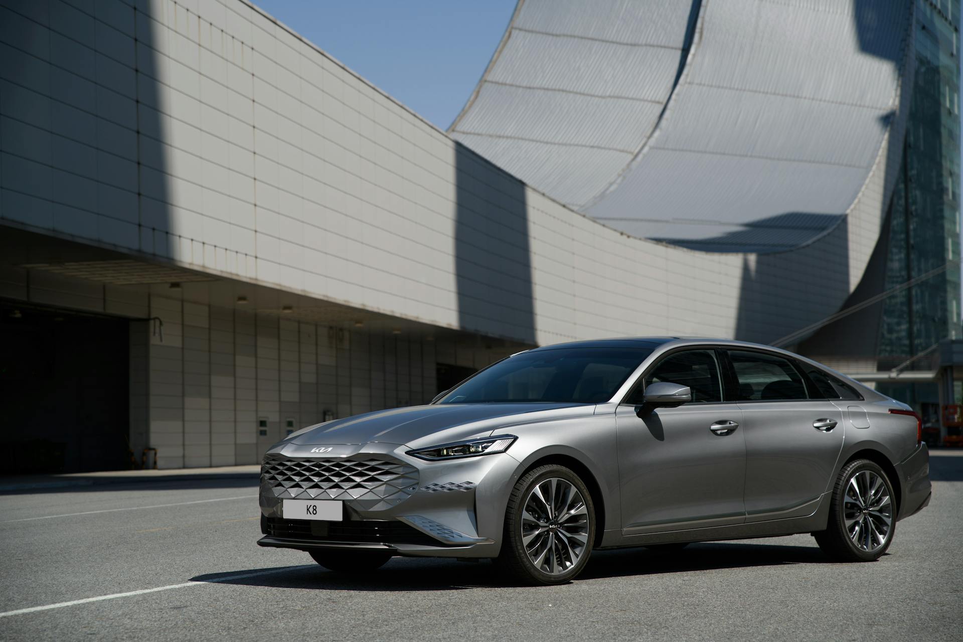 Silver Car Parked in Front of Futuristic Building