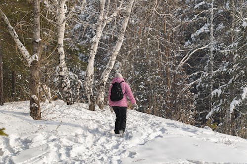 A Person Walking on Snow Covered Ground