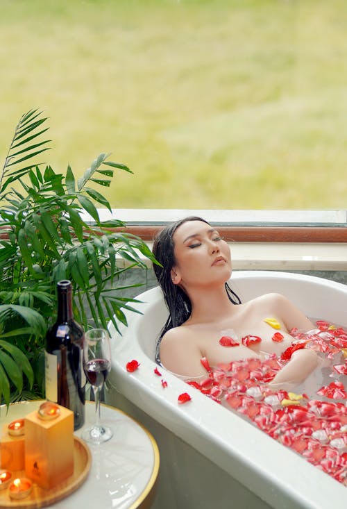 Woman Having a Bath with Rose Petals 