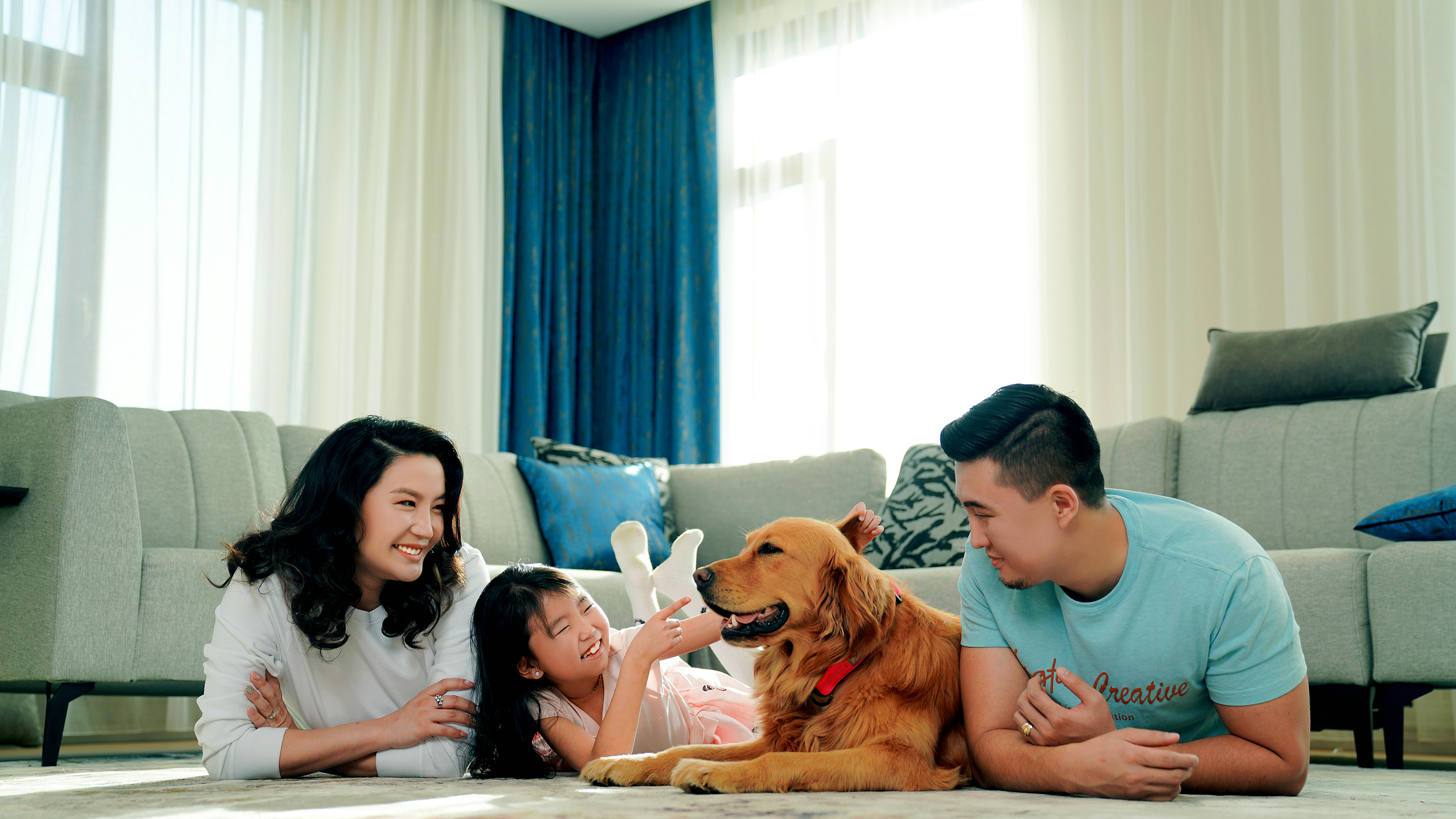 family lying on the floor with a dog