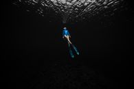 Female Free Diver Immersed in Dark Waters