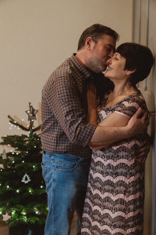 Man and Woman Kissing near Christmas Tree
