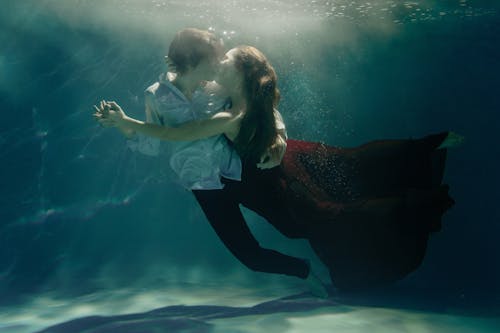 Man and Woman Dancing and Kissing Underwater