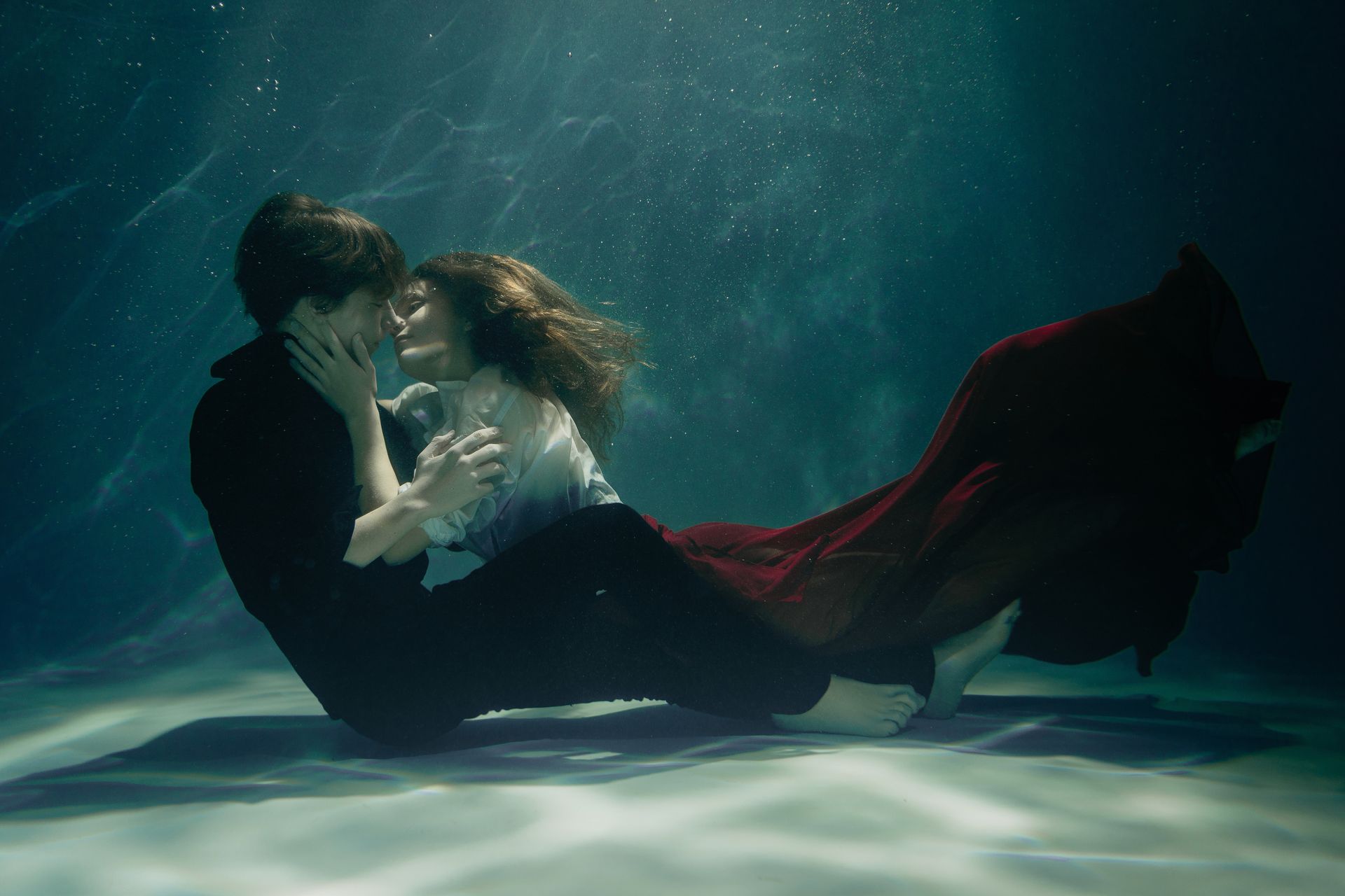 A Couple Embracing and Kissing Underwater