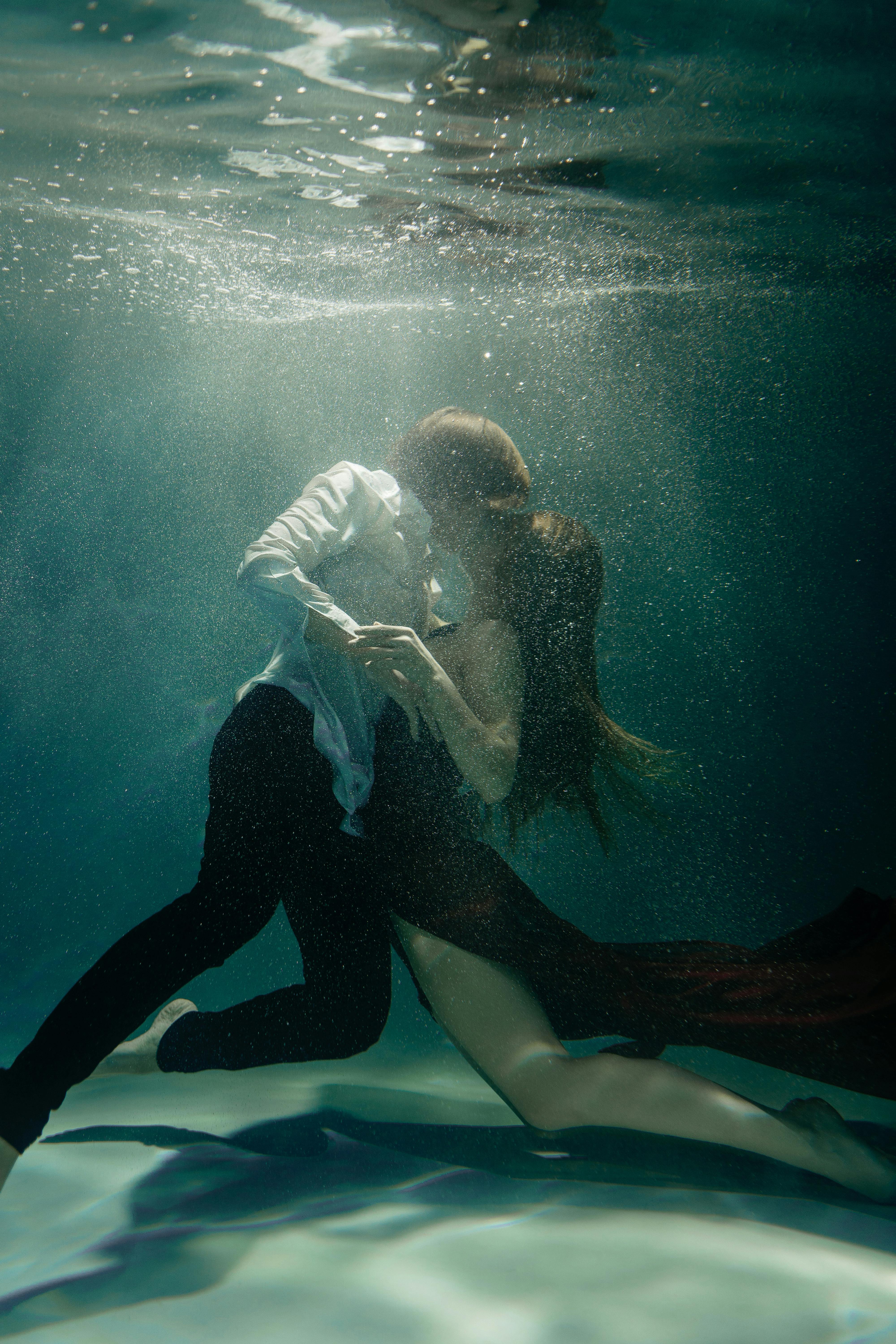 a couple dancing and kissing underwater