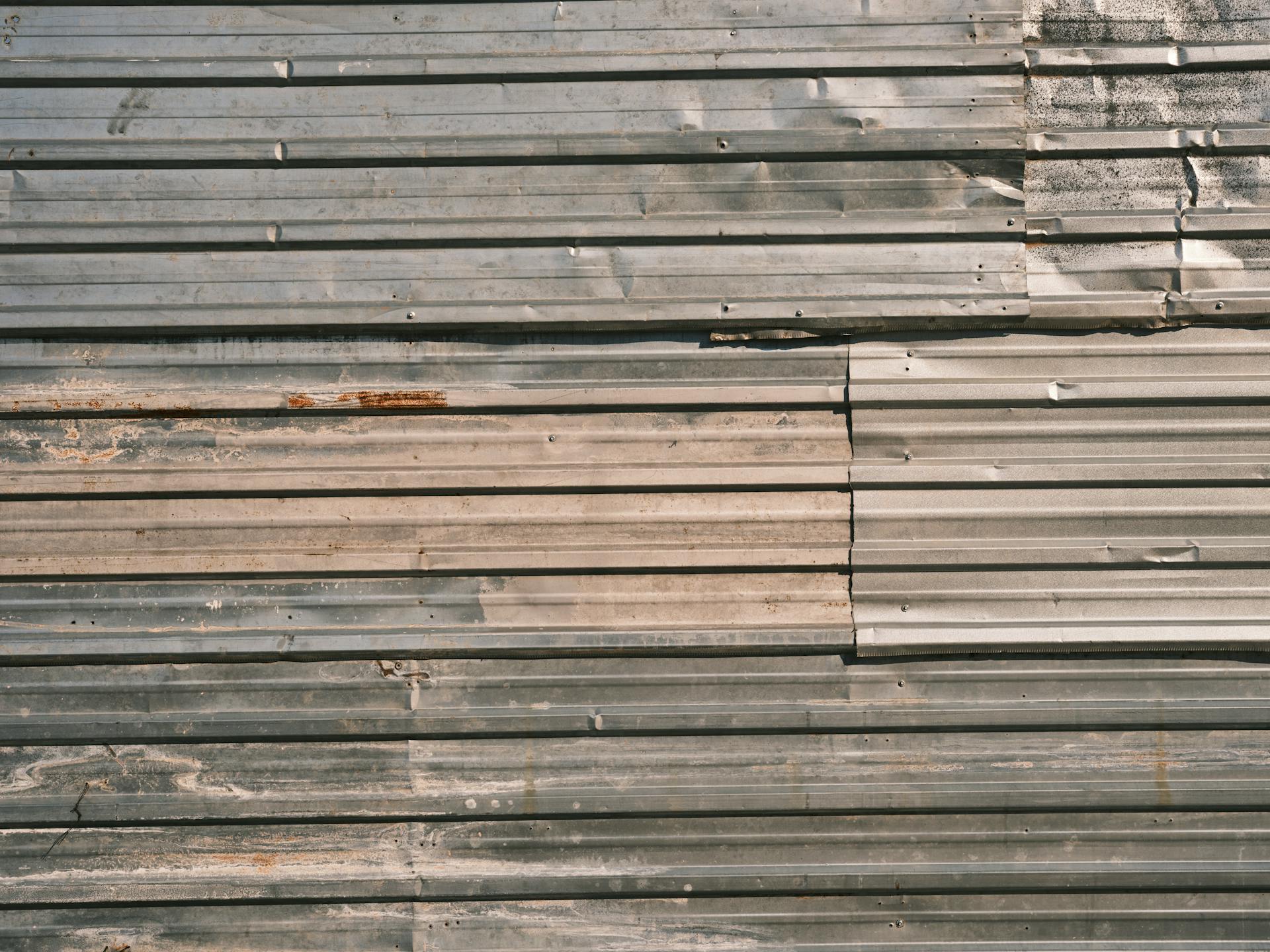 Close-up of a corrugated metal wall displaying rustic texture and patina, ideal for industrial themes.