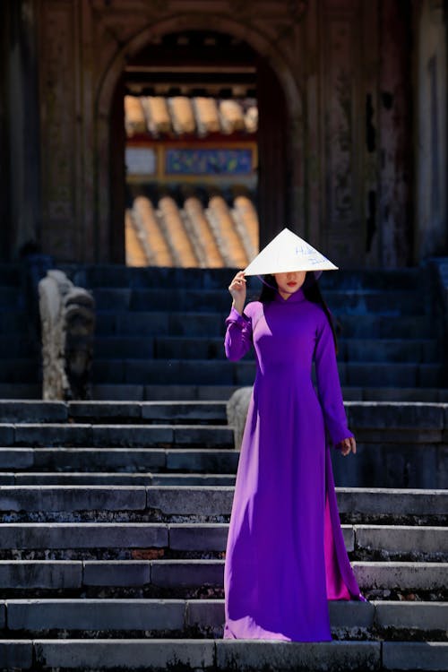 Free Woman in Purple Long Sleeved Dress Standing on the Stairs Stock Photo