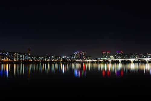 무료 밤 시간 동안 수역 근처 도시 스톡 사진