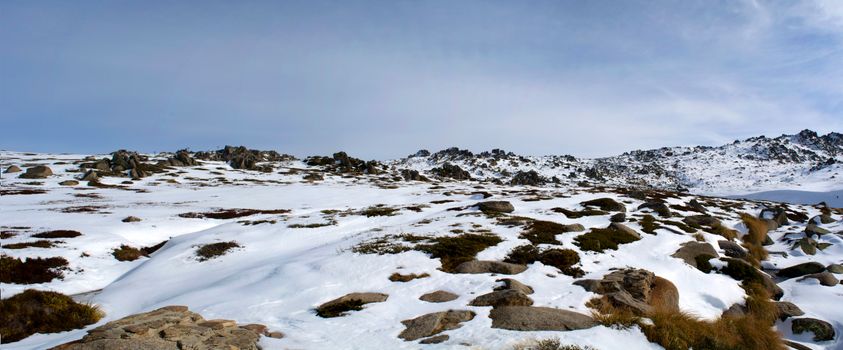 Scenic view of snow-covered terrain with rocks in Kosciuszko National Park, NSW, Australia.