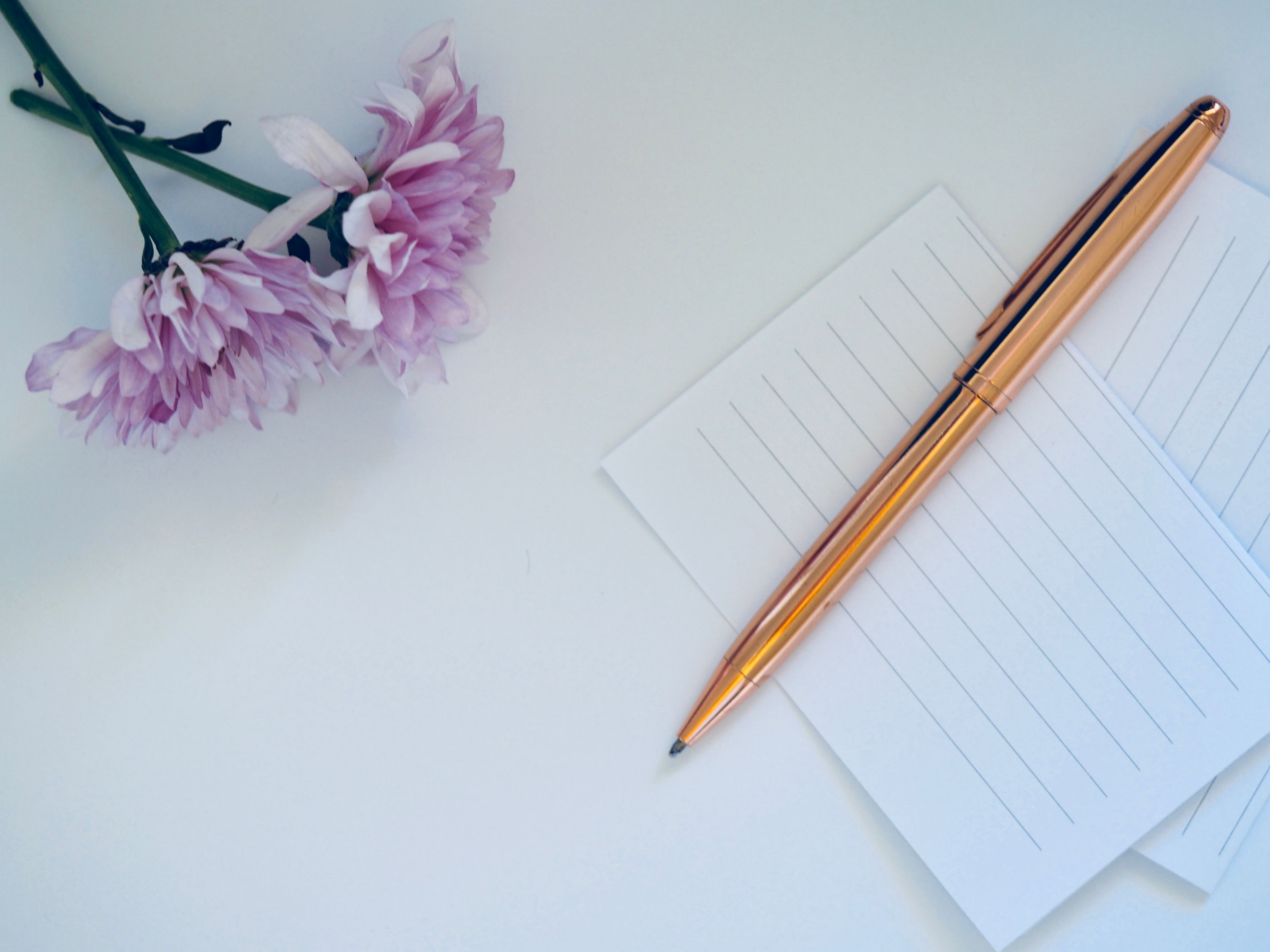 A printed one-page business letter with a pen resting on top, laid on a clean white desk