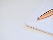 光滑的笔放在笔记本上，象征着生产力和计划