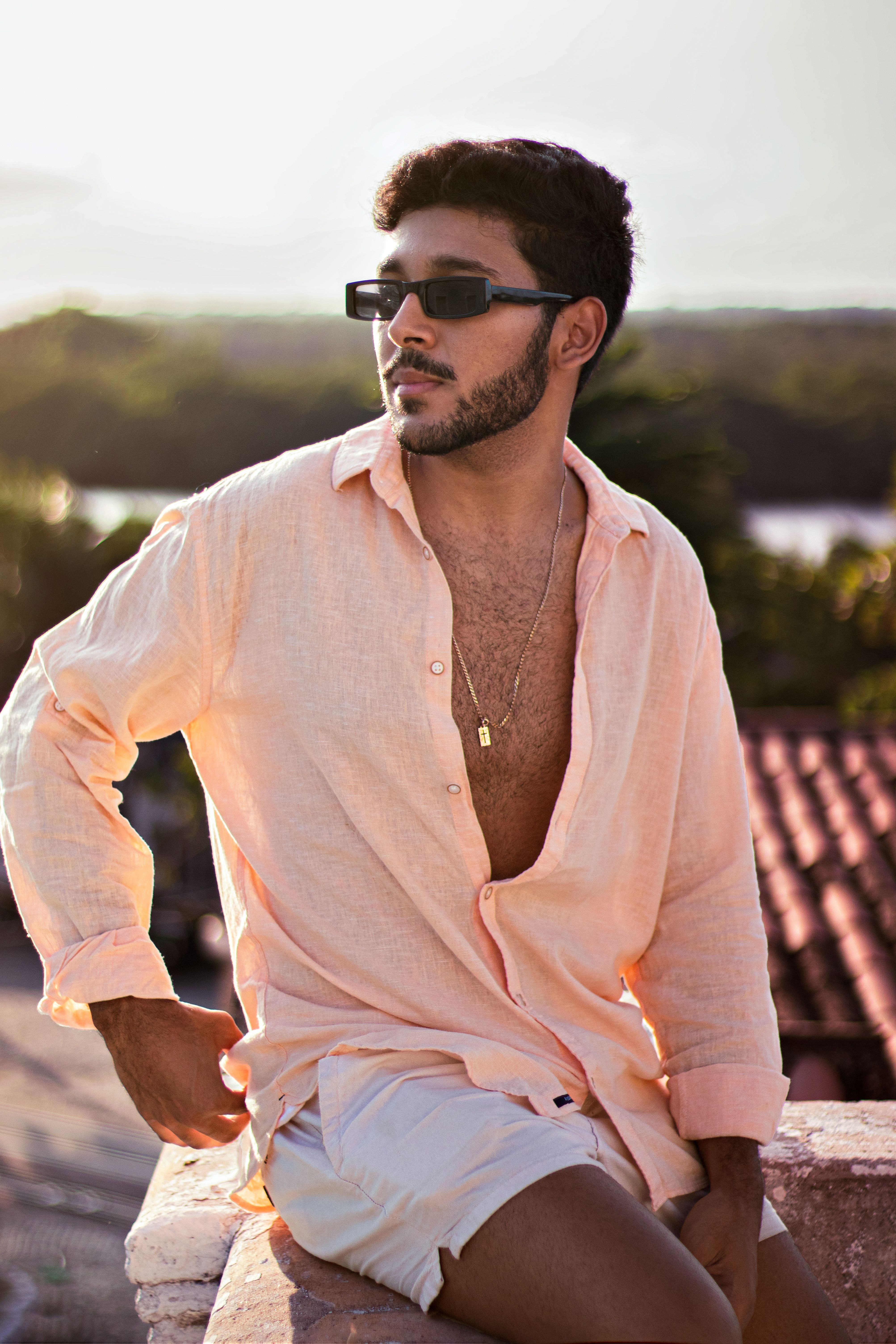Man with sunglasses poses confidently outdoors in João Pessoa, Brazil.
