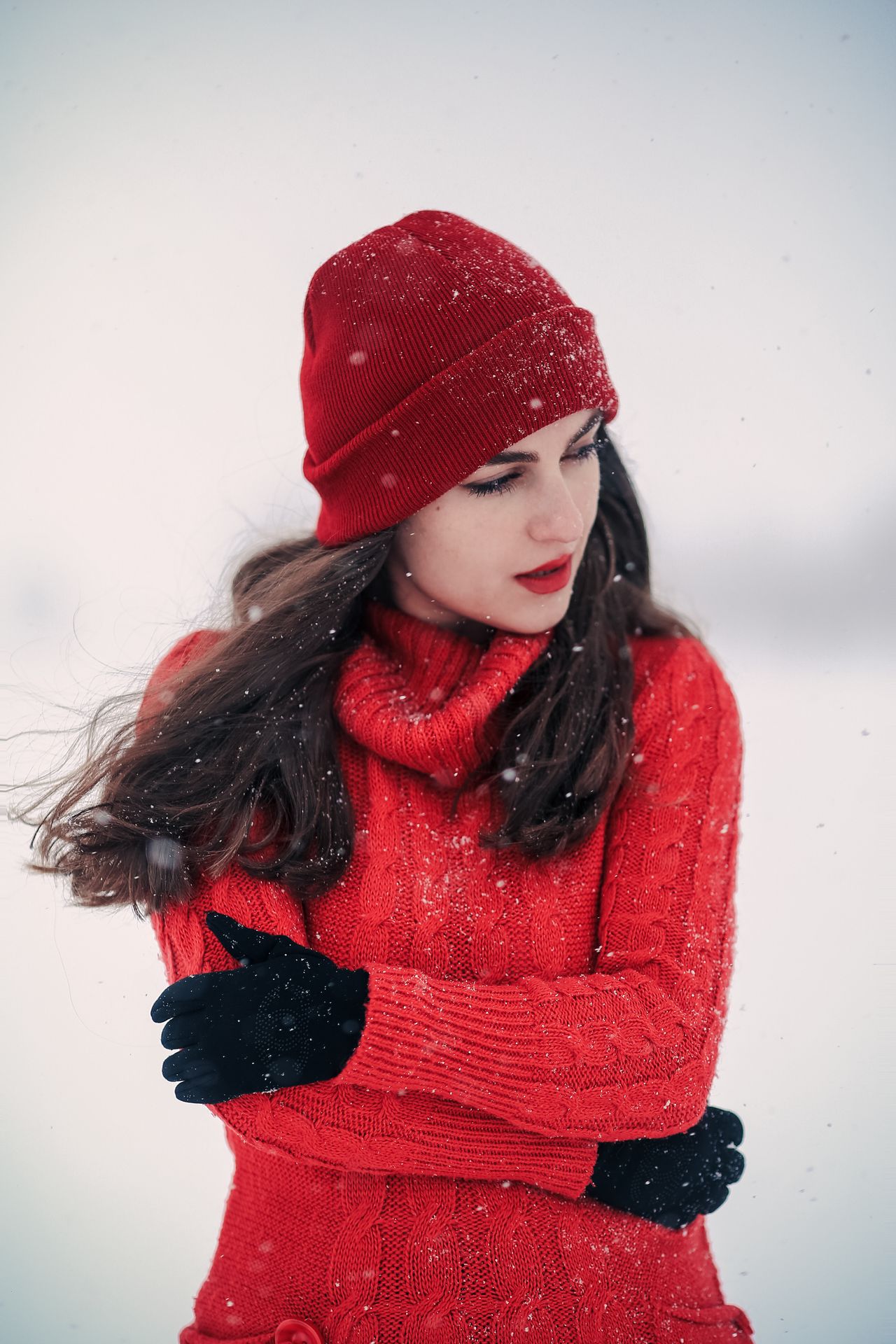Woman in a red toque, red knit sweater and black gloves