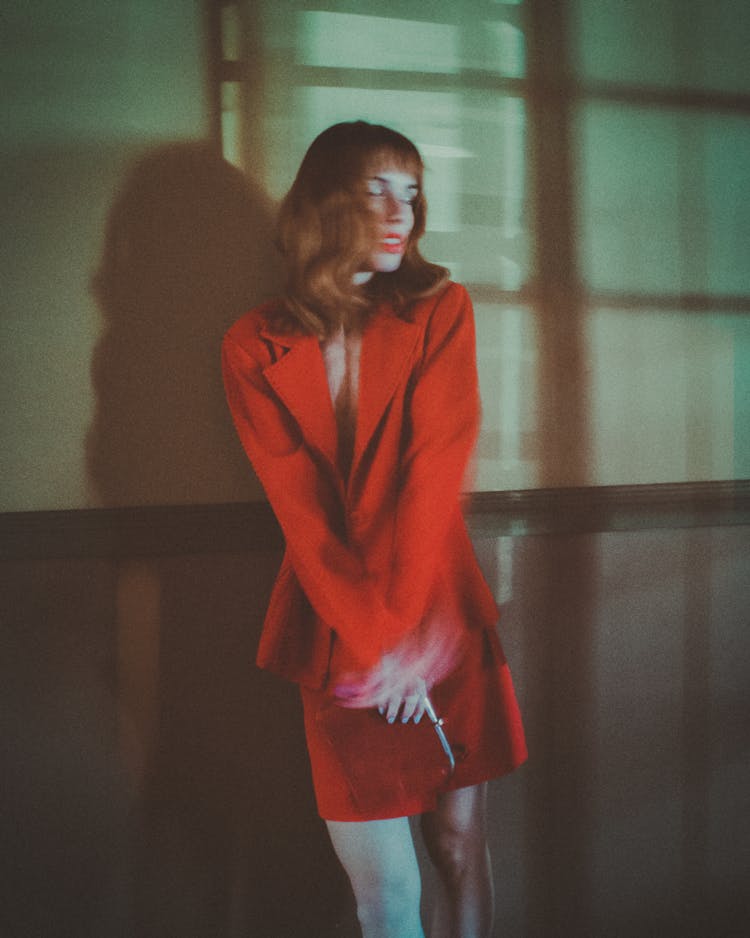 Woman In Red Blazer And Skirt Near Wall