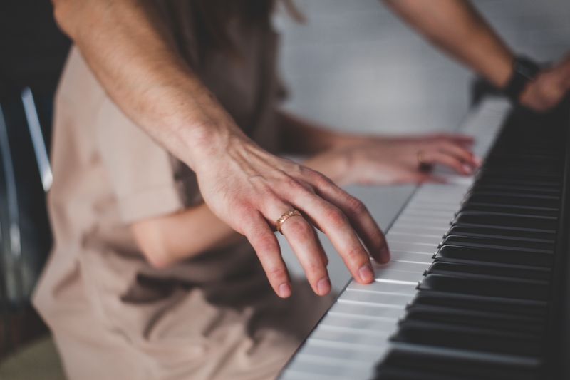 Close-up of hands playing piano keys