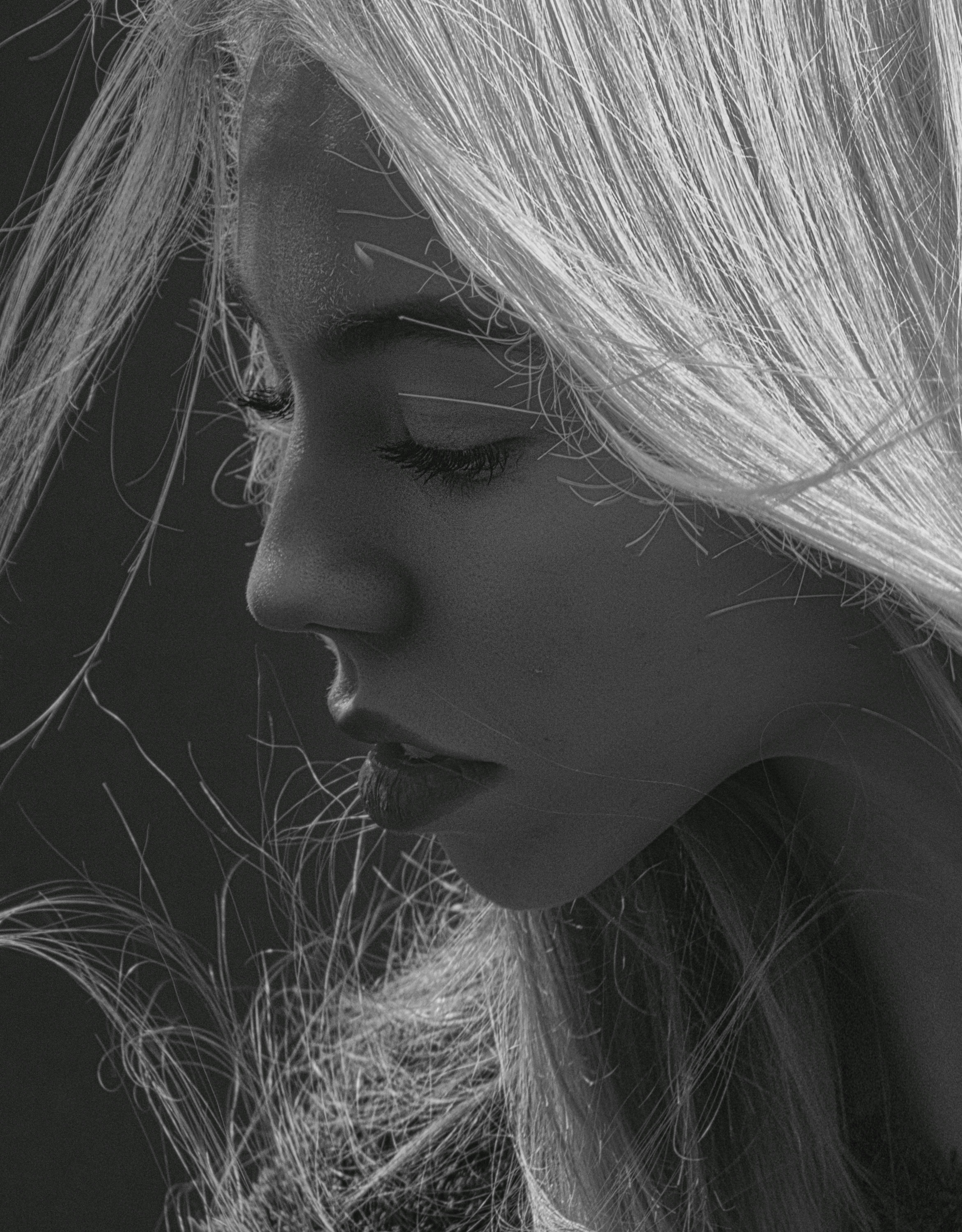 Close-up portrait of a woman in grayscale, highlighting expressive emotions.
