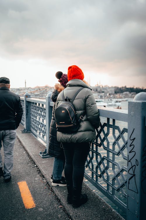 Women Wearing Jacket Standing in Front of a Railing