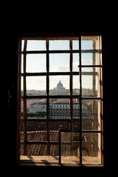 Captivating view of St. Peter's Basilica framed by a window in Rome, capturing the essence of the city.